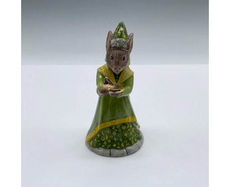 Hand decorated porcelain figure of a bunny in a green medieval gown with yellow astrological symbols. The bunny is shown hold