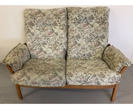 An Ercol light wood framed 2 seater sofa with floral and hummingbird design upholstered cushions. Slat backed wooden frame. A