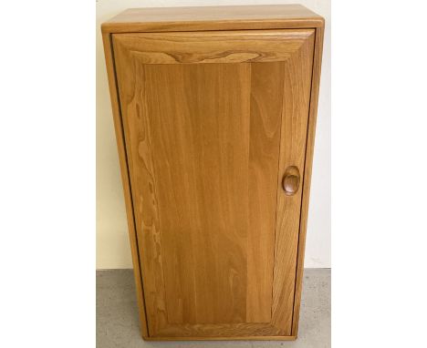 A vintage light elm Ercol Windsor single door cupboard with 2 adjustable interior shelves.  Approx. 81.5cm tall x 47cm wide.