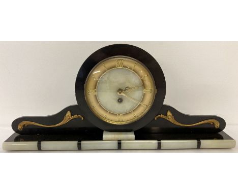 An Art Deco black slate and onyx mantle clock with gold scroll applique detail. Onyx face with goldtone hour markers and hand