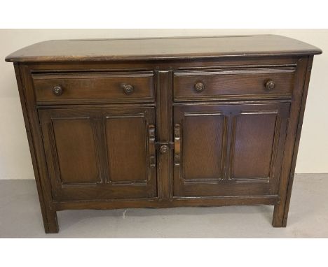 A vintage mid century dark wood Ercol double door sideboard. 2 door, 2 drawer cupboard with fixed interior shelf, sliding doo