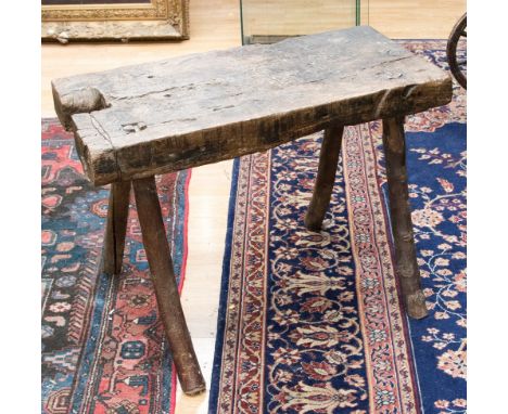 A vernacular work bench or low table, the planked top supported on four natural birch twig legs