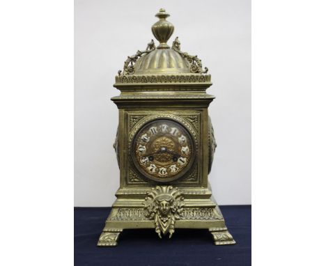 A late 19th Century French brass bracket clock, the case of Baroque design, finial and cupola, inset enamel Roman numerals to