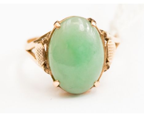 An 18ct gold ring with a Jade type oval cabochon stone, size M with a total gross weight of approx 3.2gms 