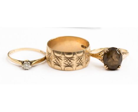 Three nine carat gold rings, comprising: a claw set diamond ring, approx size K½; a  claw set oval smokey quartz ring and a h