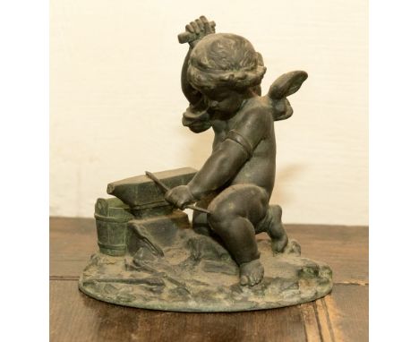 A 19th Century bronzed figure of Cupid sharpening his arrow 