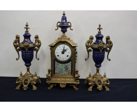 An Italian 'Imperial' brass mantle clock and garniture, the enamelled dial having Roman numerals, minor damage to the dial, n