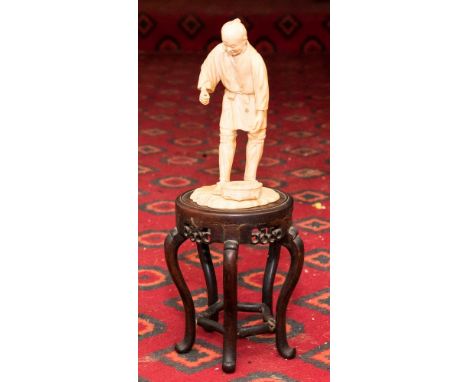 A 19th Century Japanese Okimono on stand, in the form of a fisherman, Meiji