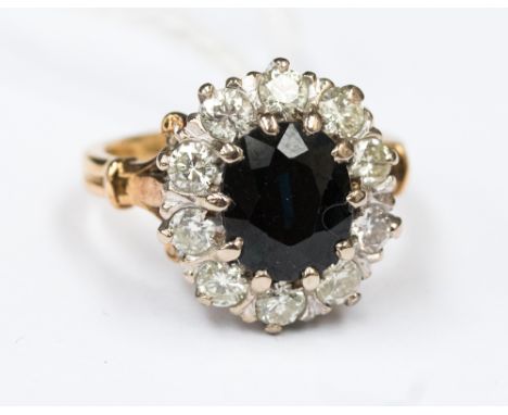 An 18ct sapphire and diamond cluster ring in yellow metal (probably 18ct, set with an oval sapphire approx 7x9mm in size with