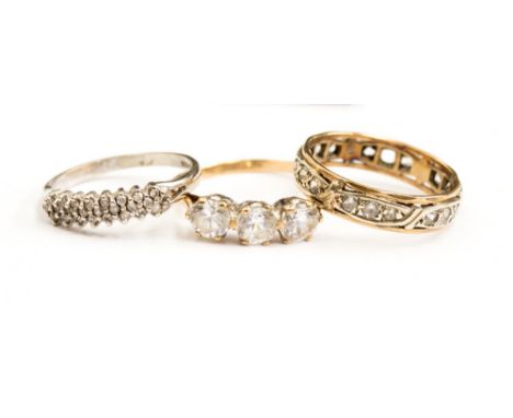 Three 9ct gold rings comprising of a diamond multi row half eternity ring set in 9ct white gold, size M1/2, a 9ct and cz full