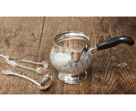 An oriental silver sauce pan, circular , the body chased with stylised and bamboo and foliage, with side ebonised handle toge