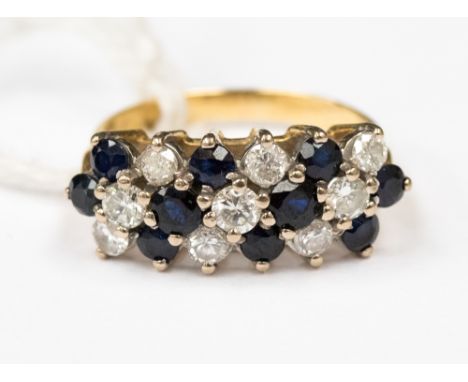 A sapphire and diamond yellow metal probably 18ct gold dress ring, set with three mixed rows rows of alternate sapphire and d