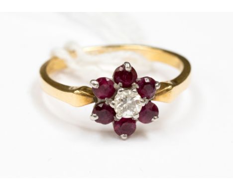 A ruby and diamond flower cluster ring, claw set central brilliant cut diamond of approx 0.2 ct and six surrounding rubies, s