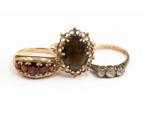 A group of three rings comprising a 9ct gold dress ring set with five garnets, size N; together with 9ct gold ring with an or