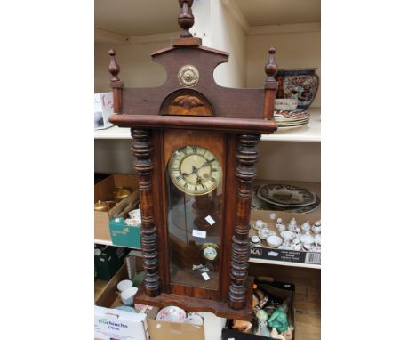 A Victorian wall clock with pendulum and key in working order 