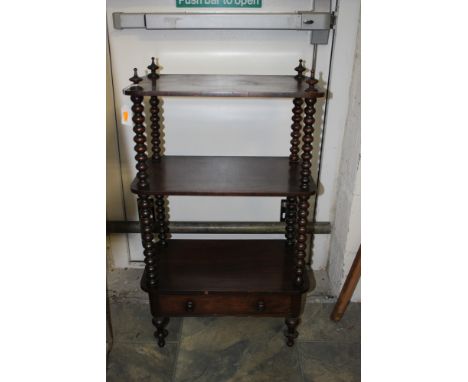 An early Victorian rosewood what-not, of three-tier form, each tier raised on bobbin turned columns, the fitted with a single