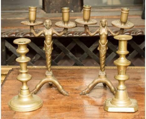 A pair of brass Mermaid and Merman candelabra, twin branched, together with two brass candlesticks (4)