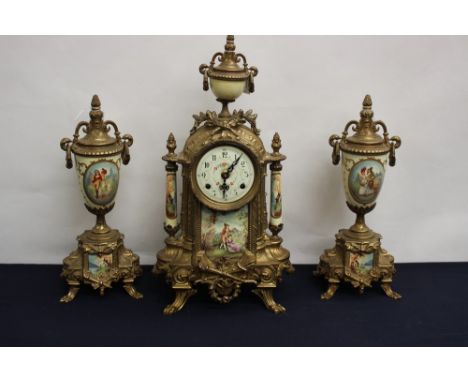 A brass mantle clock and garniture, the dial having Arabic numerals, stenciled decoration throughout, no key 