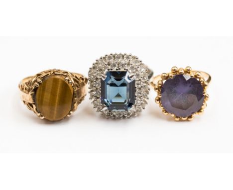 A group of three dress rings comprising a 9ct gold tigers eye set signet ring, size R; together with a yellow gold synthetic 