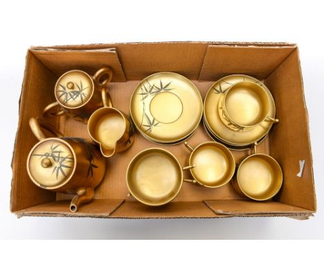 A Japanese papier mache gilt and black tea set, comprising tea pot, milk jug, sugar bowl, six cups and six saucers, mid 20th 