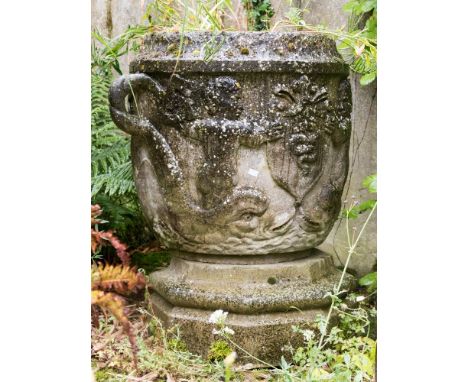 A large stone vase planter, twin handled form, carved in relief with putti riding dolphins, the handles in the form of stylis