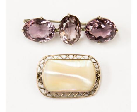 A silver, Victorian brooch with three large faceted amethyst stones and a white metal and mother of pearl brooch (2)