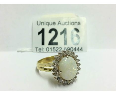 An 18ct white gold oval opal and diamond ring, size U