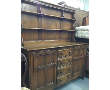 Ercol elm dresser with raised back, four central doors flanked by two cupboards 145 cm wide, 171 cm high