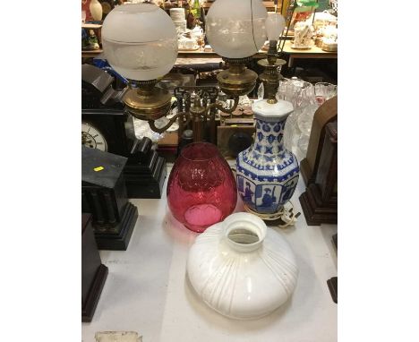 Chinese blue and white porcelain table lamp, together with a brass oil lamp, brass table lamp and cranberry glass oil lamp sh