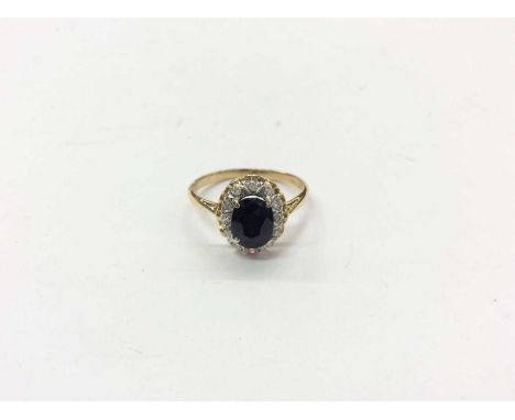 18ct gold sapphire and diamond cluster ring with a central oval faceted blue sapphire surrounded by a border of brilliant cut