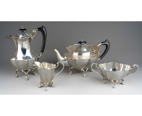 A George V silver tea set to include teapot, hot water\coffee pot, sugar bowl and milk jug, shaped oval bodies on raised open
