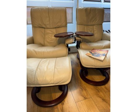 A pair of ""Stressless"" revolving/reclining leather armchairs with extendable headrest and swivel occasional table and match