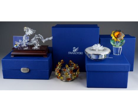 Collection of boxed Swarovski crystal pieces to include a Topaz leaves tea light, dragon on stand, sunflower in a plant pot, 