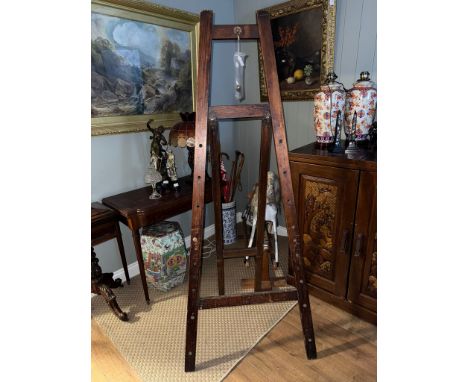 An early 20th century stained pine picture easel, bears worn transfer mark for ESA, comes with two wooden pegs, closed height