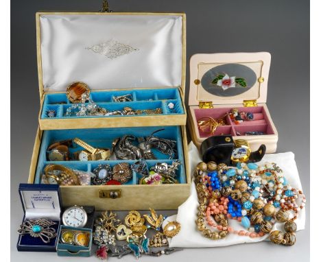 A collection of costume jewellery in two jewellery boxes and a bag, including bead necklaces, a heart shaped pendant with rub