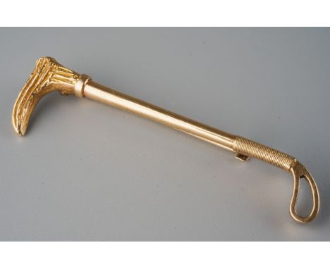 A 9ct gold bar brooch. Designed as a riding crop brooch. Hallmaked 9ct gold Birmingham 1984, approx length of brooch 43mms, a