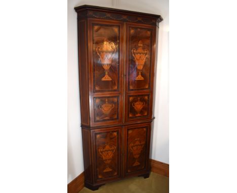 A George III mahogany and satinwood inlaid freestanding flat fronted corner cupboard, the moulded cornice above ribbon tied h