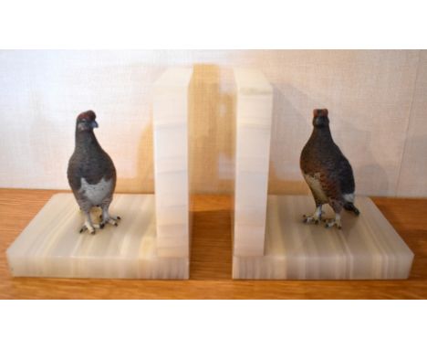 A pair of 1930s Austrian cold painted figures of grouse mounted on polished white onyx bookends, height 13cm, length 12.5cm (