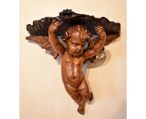 A pair of Italian carved pine wall shelves with winged cherub supports, width 35cm, depth approx. 31cm (2).Provenance: The co