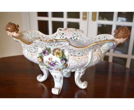 A large circa 1900 Continental porcelain centrepiece with pierced shaped rim, twin female mask ends and hand painted througho