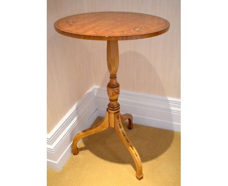 A painted satinwood circular occasional table, the top decorated with three floral sprays above a baluster ring turned centra