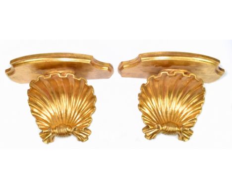A pair of Italian gilt wood wall brackets with shaped platforms above scallop shell bracket, width 42cm (2).Provenance: The c