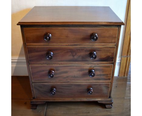 An early 19th century mahogany boxwood strung chest of four long graduated drawers, raised on ogee bracket feet, the whole of