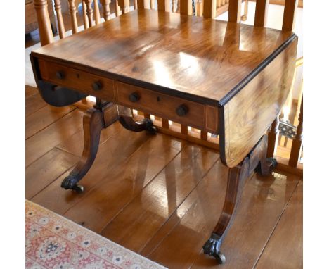 A Regency rosewood and line inlaid sofa table, the rectangular top with twin flaps above two frieze drawers, opposing two fau