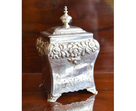 An early Victorian hallmarked silver tea caddy with hinged lid above floral embossed band, lower engraved detail and spreadin