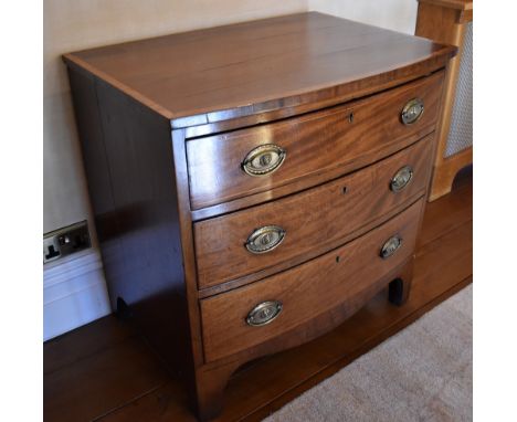 An early 19th century mahogany line inlaid and crossbanded bowfront chest of three gradated drawers of small proportions, rai