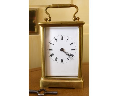 A circa 1900 French brass carriage clock, the rectangular white enamelled dial set with Roman numerals and striking on a coil