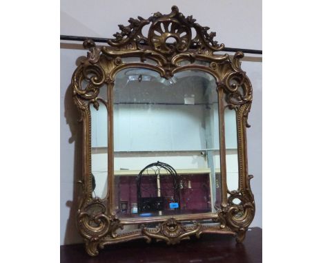 A 19th century rococo revival looking glass with shaped bevelled centre plate and subsidiary sectional plates, the elaborate 