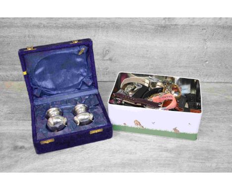 Cased white metal cruet set comprising salt and pepper pots raised on three feet together with a box of various Gents and Lad