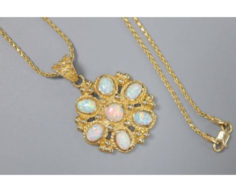 A Turkish 585 and white opal flowerhead pendant on chain by Istor, the pendant set with seven cabochon opals interspaced by g